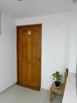 a wooden door in a white room with a potted plant at Apartamento Familiar para 6 personas in Cartagena de Indias