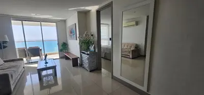 a living room with a mirror and a couch at Lujo frente a la playa in Cartagena de Indias