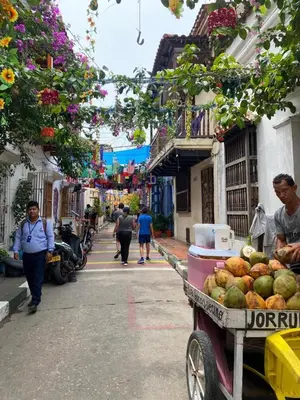 a man pushing a cart full of fruit on a street at Hospedaje Doña Argenida in Cartagena de Indias