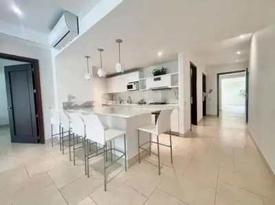 a white kitchen with a bar with white stools at Modern Comfort - Spacious 2BR in Walled City in Cartagena de Indias