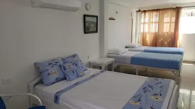 a room with two beds with blue and white sheets at Alojamiento Serena Tu Casa en la Playa in Cartagena de Indias