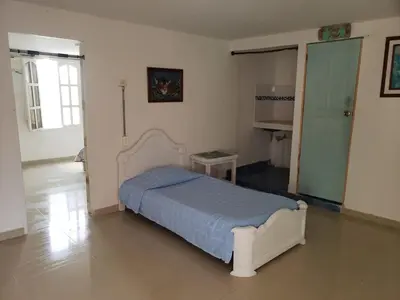 a bedroom with a bed in the middle of a room at Alojamiento Serena Tu Casa en la Playa in Cartagena de Indias