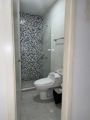 a bathroom with a toilet and a glass shower at Rincón sereno barranquilla in Barranquilla