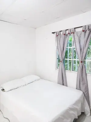 a white bed in a room with a window at Apartamento hostal oasis in Puerto Colombia