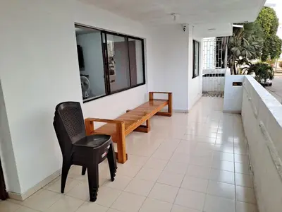a porch with a wooden bench and a chair at Apartamento para Vacaciones in Cartagena de Indias