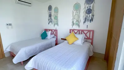 two beds in a room with white walls at Magico Apartamento Frente al Mar 3 Habitaciones TR51 in Coveñas