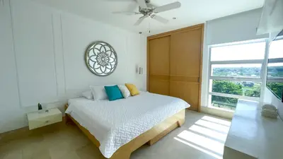 a bedroom with a bed with a clock on the wall at Magico Apartamento Frente al Mar 3 Habitaciones TR51 in Coveñas