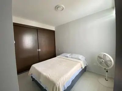 a small bedroom with a bed and a fan at Barranquilla Villa Campestre Malecon Rio Uninorte in Barranquilla