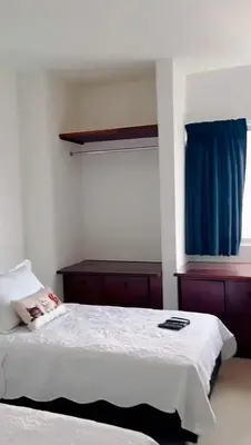 a bedroom with a bed with a blue curtain at Mirador del Laguito 13003 in Cartagena de Indias