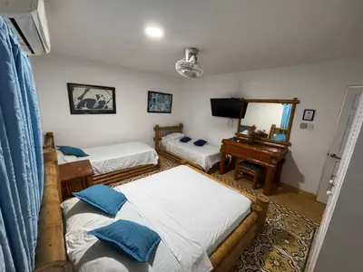 a bedroom with two beds and a mirror at Hotel Casa Confort Cartagena in Cartagena de Indias