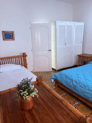 a bedroom with two beds and a vase of flowers at Hotel Casa Confort Cartagena in Cartagena de Indias