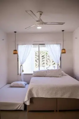 a bedroom with a bed with a ceiling fan and a window at Casa de Playa ROSANI in Coveñas