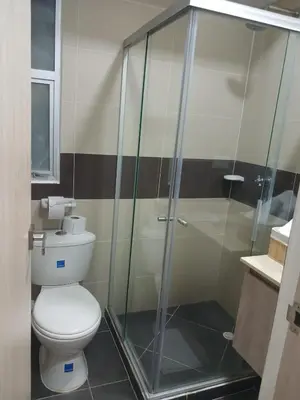 a bathroom with a toilet and a glass shower at Jardin imperial, habitaciones economica en apartamento familiar zona tranquila WIFI in Cartagena de Indias