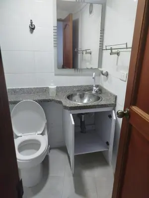 a bathroom with a toilet and a sink with a mirror at EC-AL3E APARTAESRUDIO CERCA AL MAR CON PISCINA, AIRE ACONDICIONADO Y WIFi in Cartagena de Indias