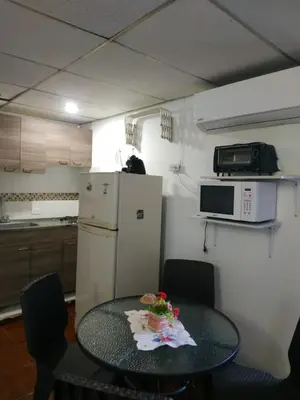 a small kitchen with a table and a refrigerator at EC-AL3E APARTAESRUDIO CERCA AL MAR CON PISCINA, AIRE ACONDICIONADO Y WIFi in Cartagena de Indias
