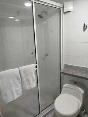 a white bathroom with a shower and a toilet at EC-AL3E APARTAESRUDIO CERCA AL MAR CON PISCINA, AIRE ACONDICIONADO Y WIFi in Cartagena de Indias