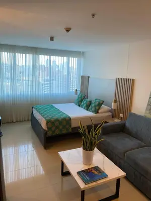 a living room with a bed and a couch at Apartamento Hotel estelar in Barranquilla