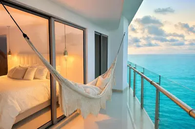 a hammock in a bedroom with a view of the ocean at by Calamari Homes - Altamar 27B1 near walled city in Cartagena de Indias