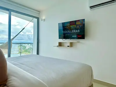 a bedroom with a bed and a tv on a wall at by Calamari Homes - Altamar 27B1 near walled city in Cartagena de Indias