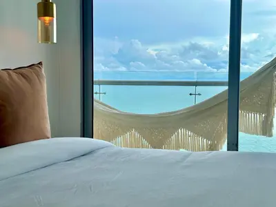 a bedroom with a bed and a view of the ocean at by Calamari Homes - Altamar 27B1 near walled city in Cartagena de Indias