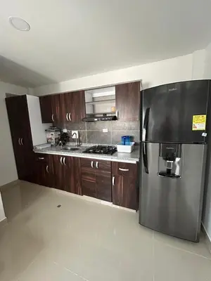 a kitchen with a stainless steel refrigerator and wooden cabinets at MONTEMAR Casa 2 in Santiago