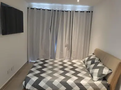a bedroom with a bed and a window with curtains at Apartamento lujoso y moderno in Cartagena de Indias