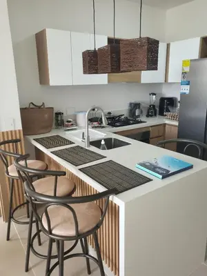 a kitchen with a sink and a counter with stools at Apartamento lujoso y moderno in Cartagena de Indias