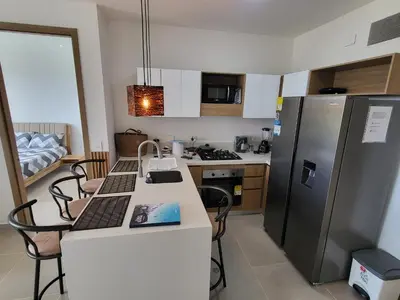 a small kitchen with a counter and a refrigerator at Apartamento lujoso y moderno in Cartagena de Indias