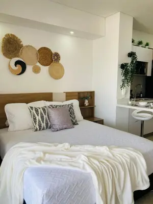 a bedroom with a large white bed with baskets on the wall at Suite piso 12 con vista mágica Ciudad CB1241 in Cartagena de Indias