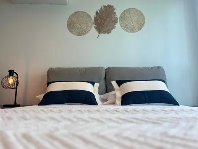 a bed with blue and white pillows on it at Apartment with direct access to the Sea in CTG in Cartagena de Indias