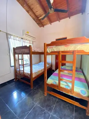 a room with two bunk beds and a ceiling at Cabaña Tolu in Santiago