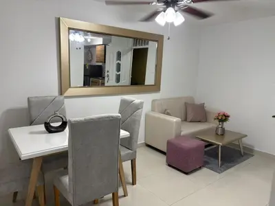 a living room with a table and chairs and a mirror at Sol Serena in Soledad