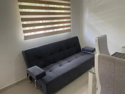 a blue couch in a living room with a window at Italia boutique Apt 2 in Barranquilla