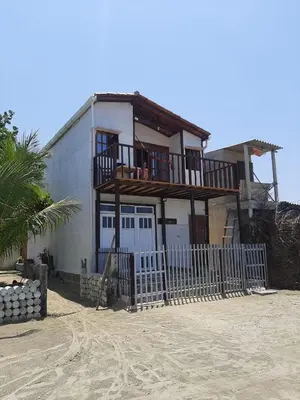 a house on the beach with a fence at Hostal Playa Descalzo in Cartagena de Indias