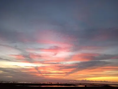 a group of people standing on the beach at sunset at Hostal playa descalzo in La Boquilla