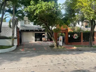 a tree in front of a building with a garage at Italia boutique #3 in Barranquilla
