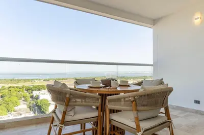 a dining room with a table and chairs and a large window at CB1631 | Piso 16 con balcón y vista panorámica in Cartagena de Indias