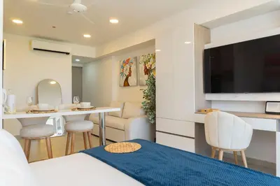 a hotel room with a bed and a table and a television at CB1631 | Piso 16 con balcón y vista panorámica in Cartagena de Indias
