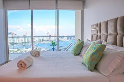 a bedroom with a large bed with a large window at Dizztravel Apart H2 - 1602 Exclusivo Bocagrande in Cartagena de Indias
