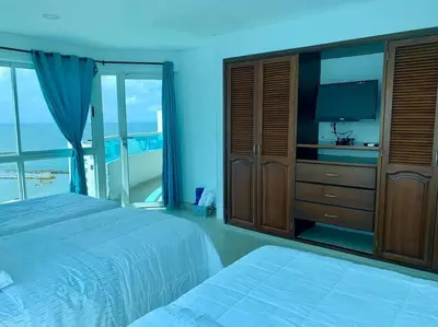 a large bedroom with two beds and a television at Tu Pent-House Con Vista al Mar! in Cartagena de Indias