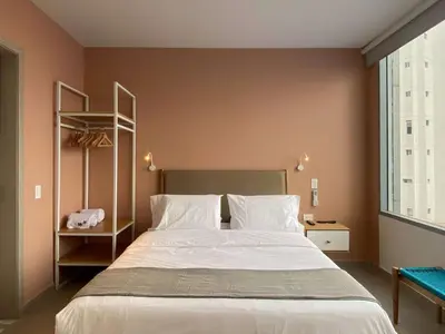a bedroom with a large bed with white sheets at San Martin by Wynwood House in Cartagena de Indias