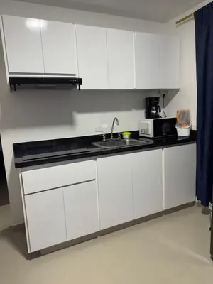 a kitchen with white cabinets and a sink and a microwave at Apartamentos el mochilero frente a la playa piso 1 apto 1 in Cartagena de Indias