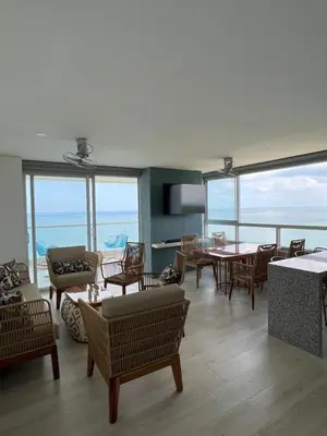 a living room with tables and chairs and windows at Apartamento Torre Vela- Coveñas in Coveñas