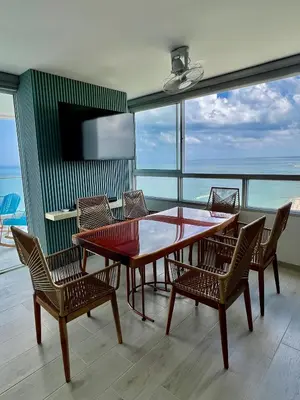 a table and chairs in a room with a view of the ocean at Apartamento Torre Vela- Coveñas in Coveñas