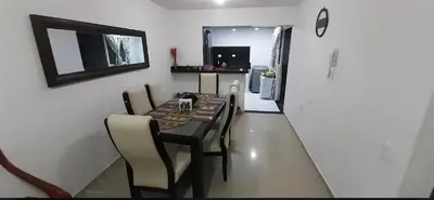 a dining room with a table and chairs and a kitchen at Habitación Caracol in Barranquilla