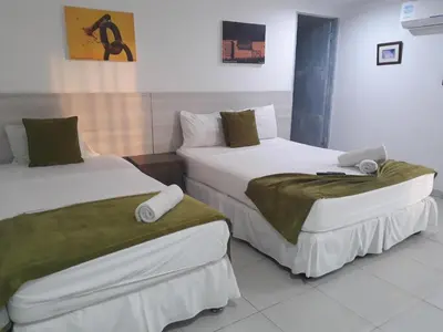 two beds in a hotel room with towels on them at Mintaka Hotel + Lounge in Cartagena de Indias