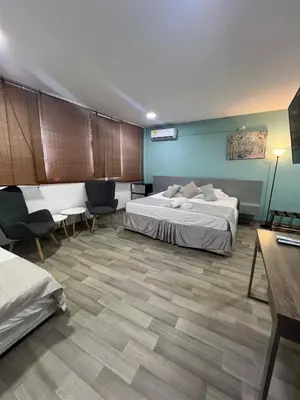 a hotel room with two beds and a table and chairs at Santa Alejandría Hotel in Cartagena de Indias