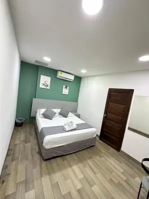 a bedroom with a bed and a green wall at Santa Alejandría Hotel in Cartagena de Indias