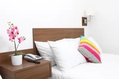 a bed with a pillow and a phone on a table at Hotel Soleira in Tolú