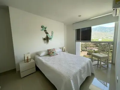 a bedroom with a bed and a large window at Apartamento Bello Horizonte Santamarta in Santa Marta